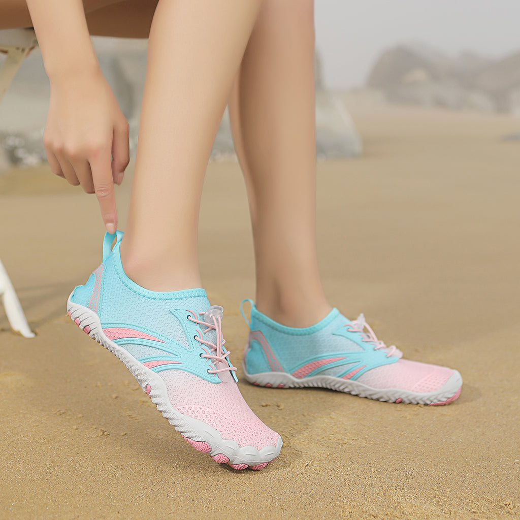 Light blue and pink water shoes on a sandy background
