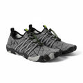 A pair of minimalist water shoes in grey and black with green accents.