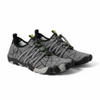 A pair of minimalist water shoes in grey and black with green accents.
