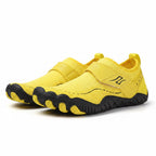 A pair of yellow children's  Barefoot slip on shoes with black textured soles.