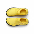 A pair of yellow children's slip on water shoes with black soles, shown from a top down view.