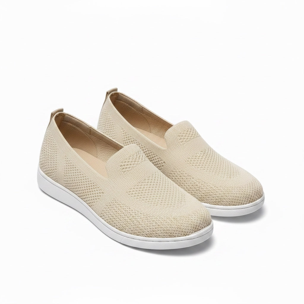 A pair of women's slip on loafers shoes  in a light beige textured knit fabric with white soles.