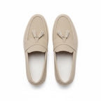 A pair of light beige leather tassel loafers shown from a top down view. 