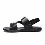 Side profile of a black minimalist barefoot sandal with adjustable buckle straps
