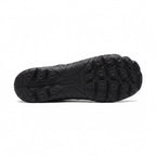 Bottom view of a black barefoot shoe showing its textured rubber traction sole