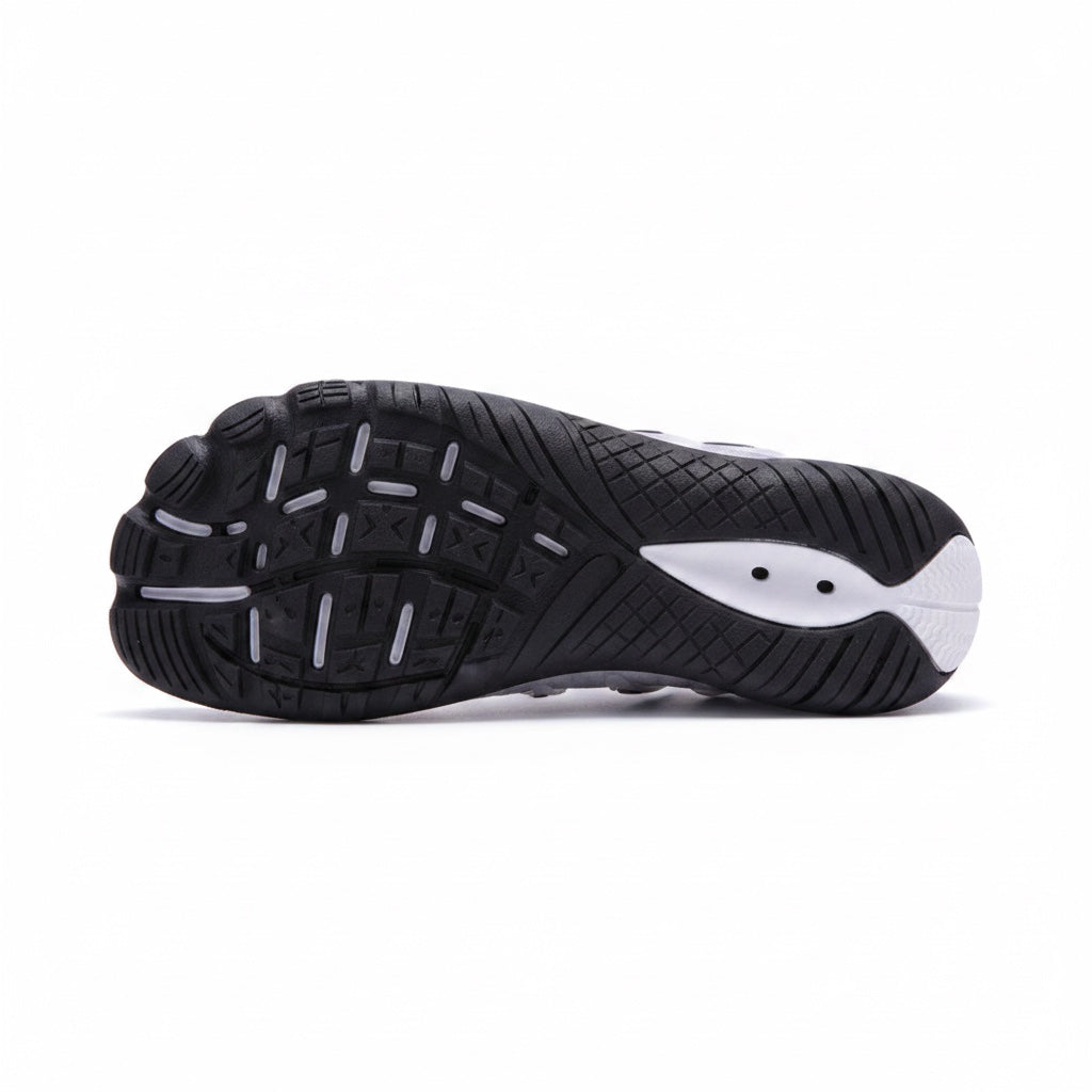 Bottom view of a black barefoot water shoe showing its flexible textured rubber sole