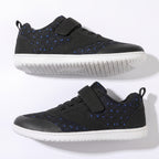 A pair of black low top children's barefoot shoes with blue dotted pattern panels, featuring hook-and-loop strap closures and white soles