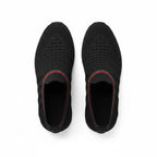 A pair of black slip on mesh sneakers shown from a top down view. 