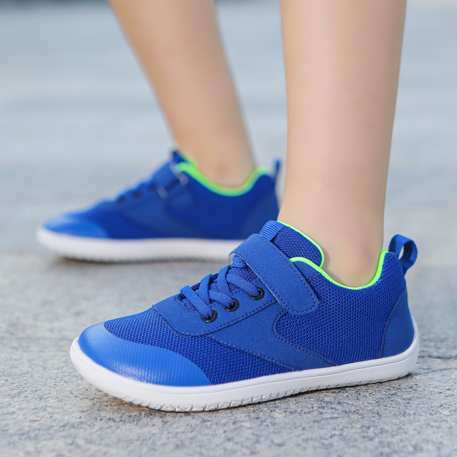 Blue children's barefoot shoes with green  trim.