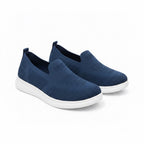 A pair of navy blue slip on loafers with a textured knit upper and white soles.