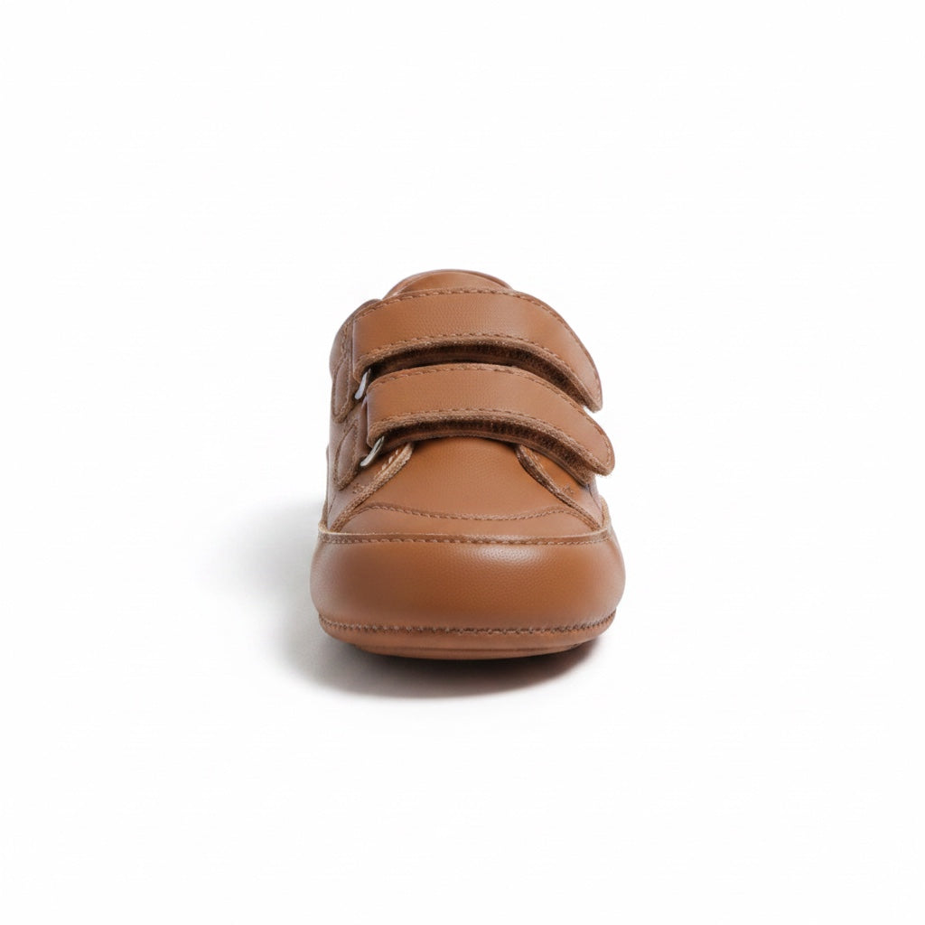 Front view of a brown baby shoe with double adjustable straps and rounded toe