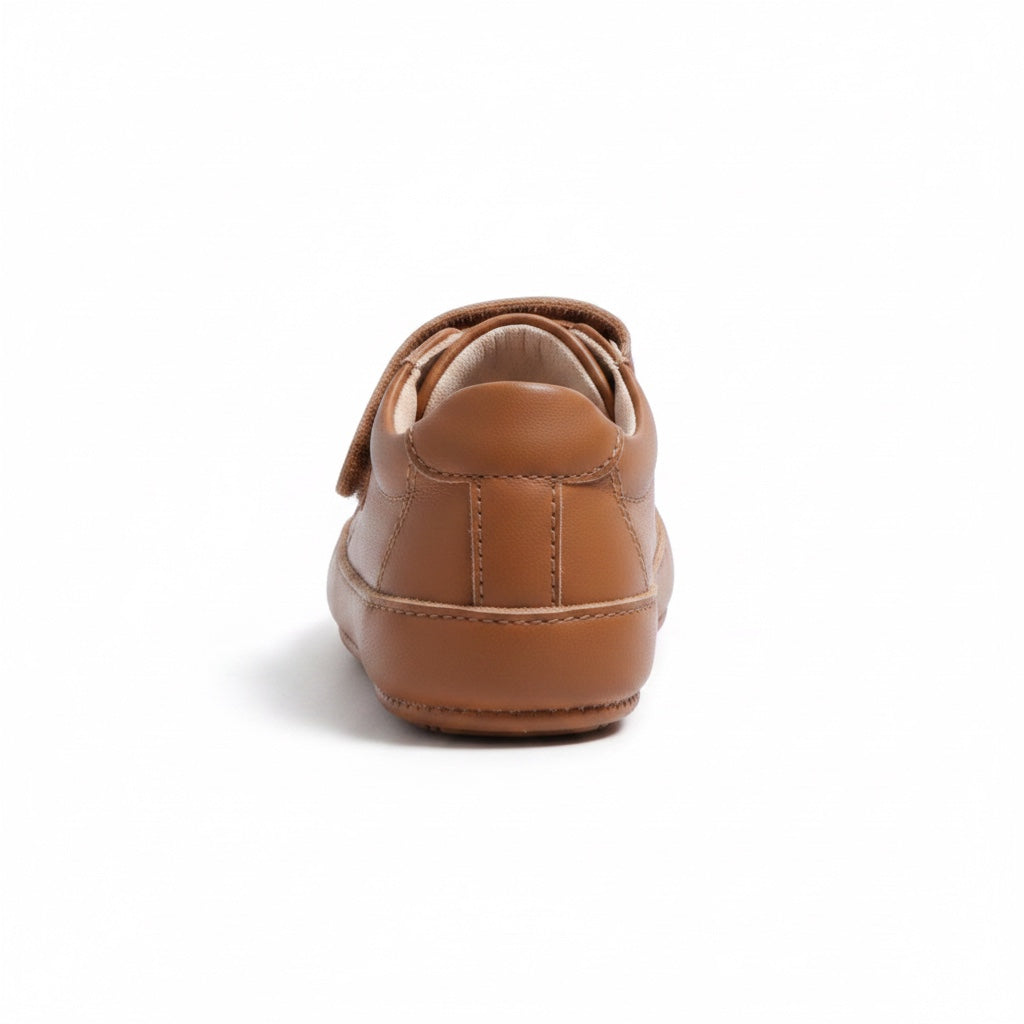 Rear view of a brown baby shoe showing its heel and flexible rubber sole