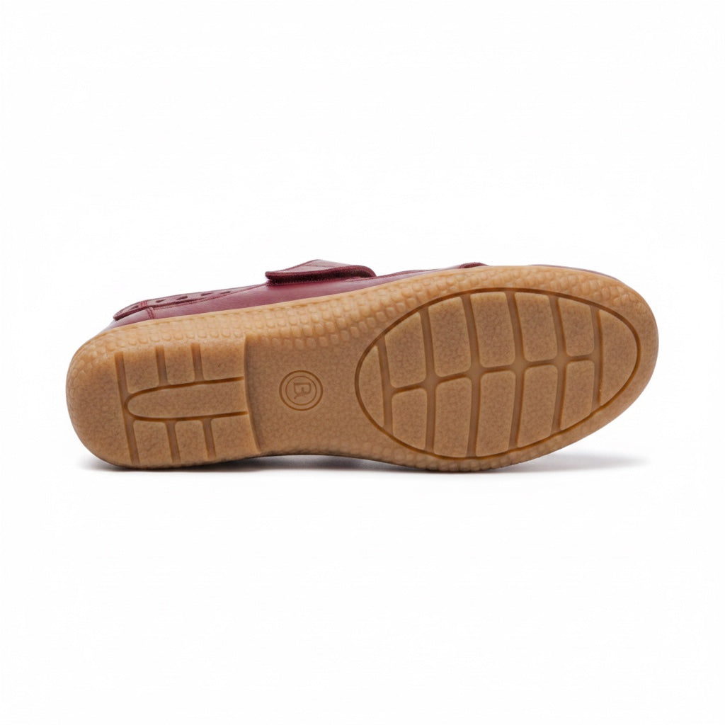 Bottom view of a burgundy comfort sandal showing the textured rubber outsole