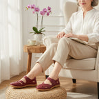 Woman wearing burgundy comfort sandals while relaxing in a bright indoor setting