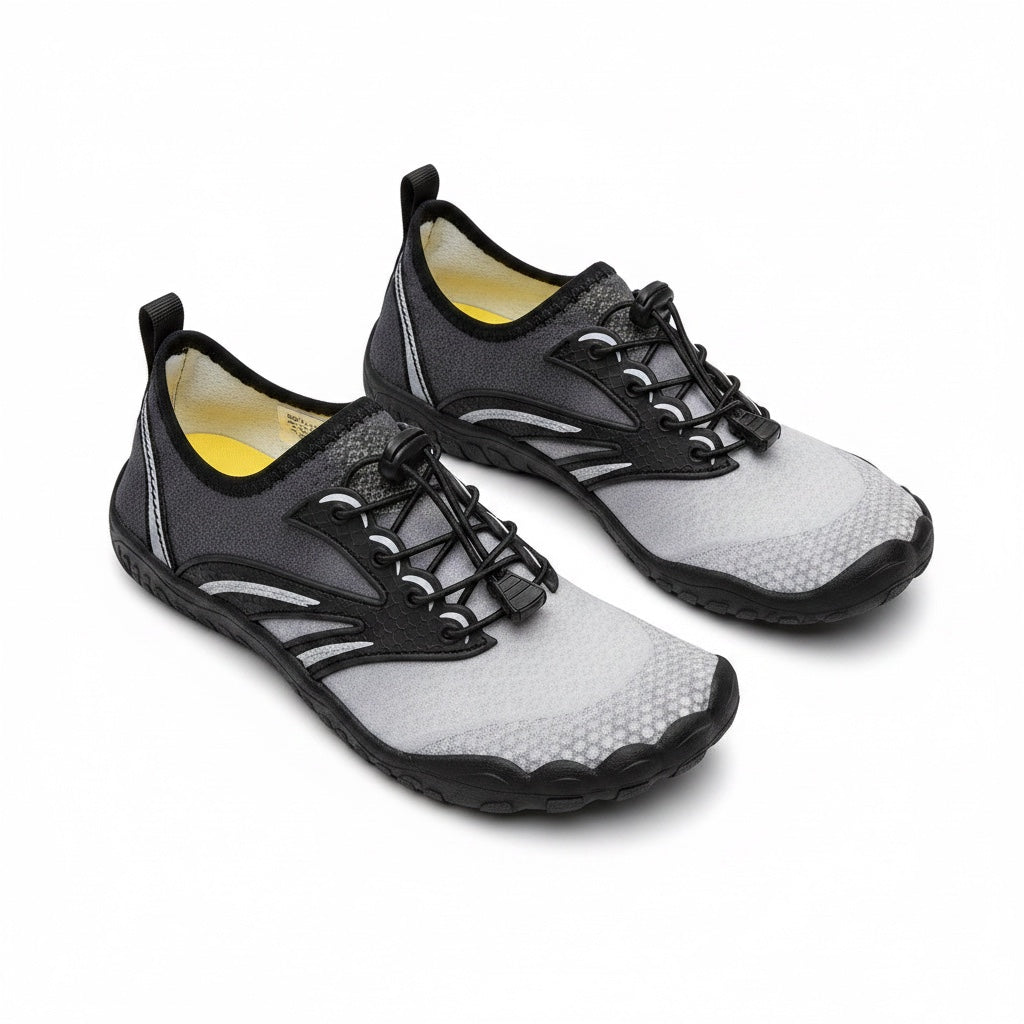 A pair of minimalist water shoes in gray and black with a bright yellow interior lining.