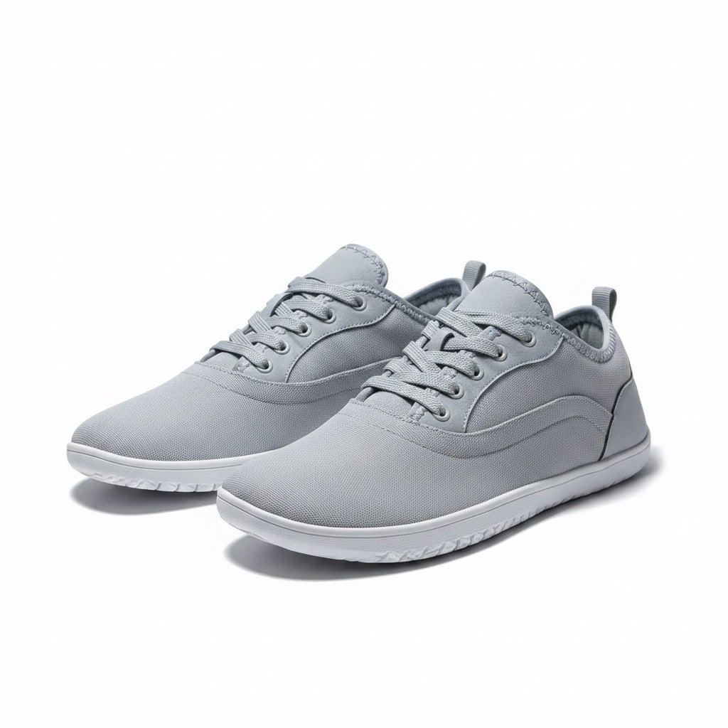 A pair of light grey low top casual Barefoot shoes with matching grey laces and white soles.