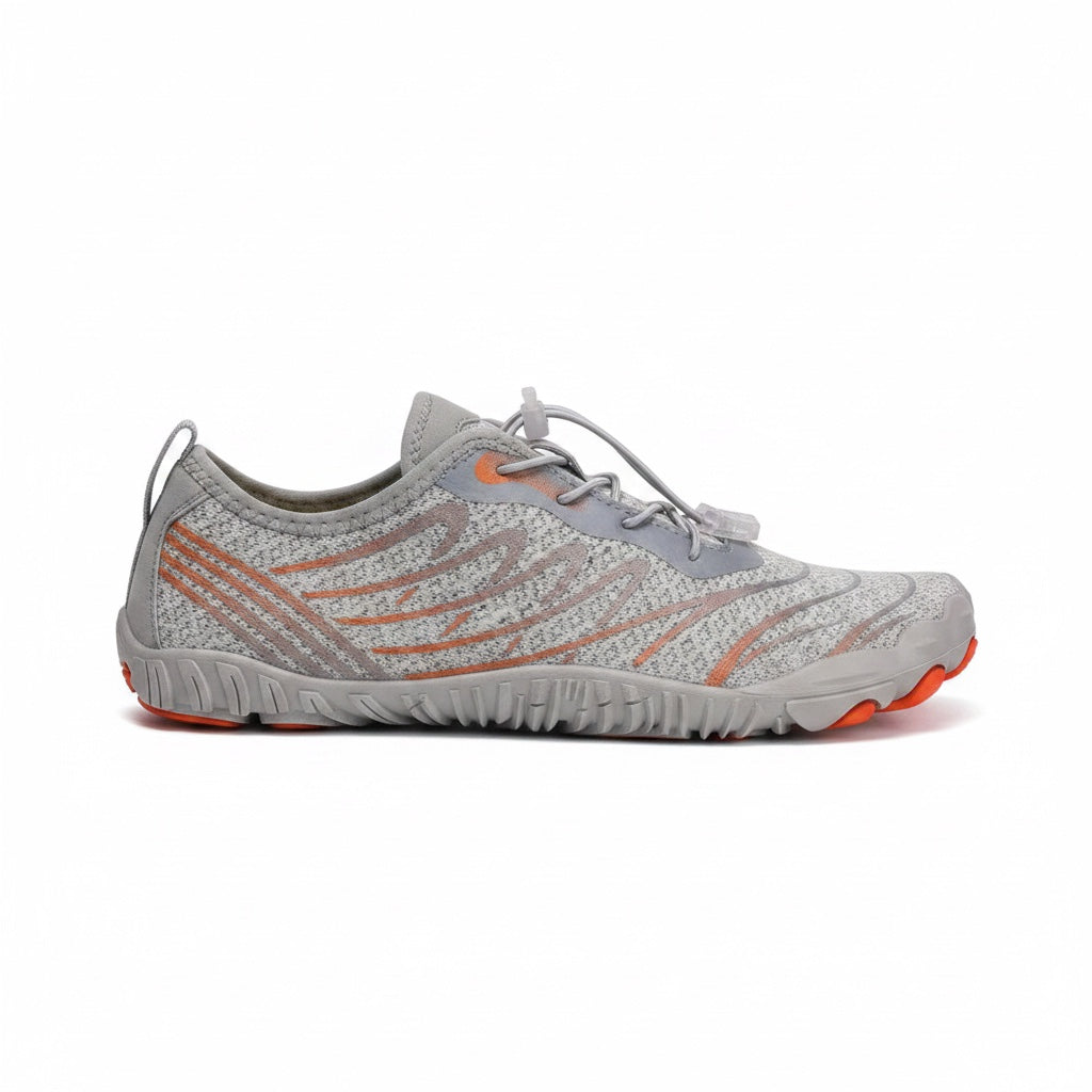 Side profile of the grey barefoot shoe with orange sole details and flexible construction.