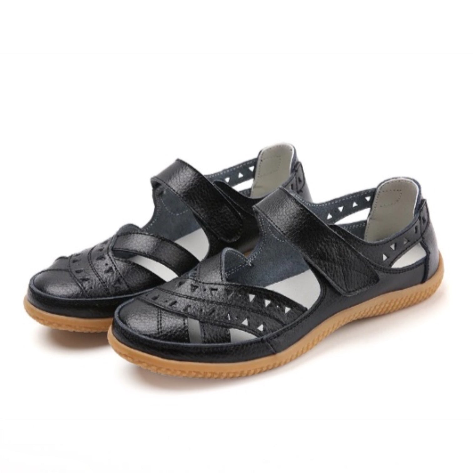 A pair of women's black leather sandals with cutout details and hook-and-loop straps, featuring a tan outsole.