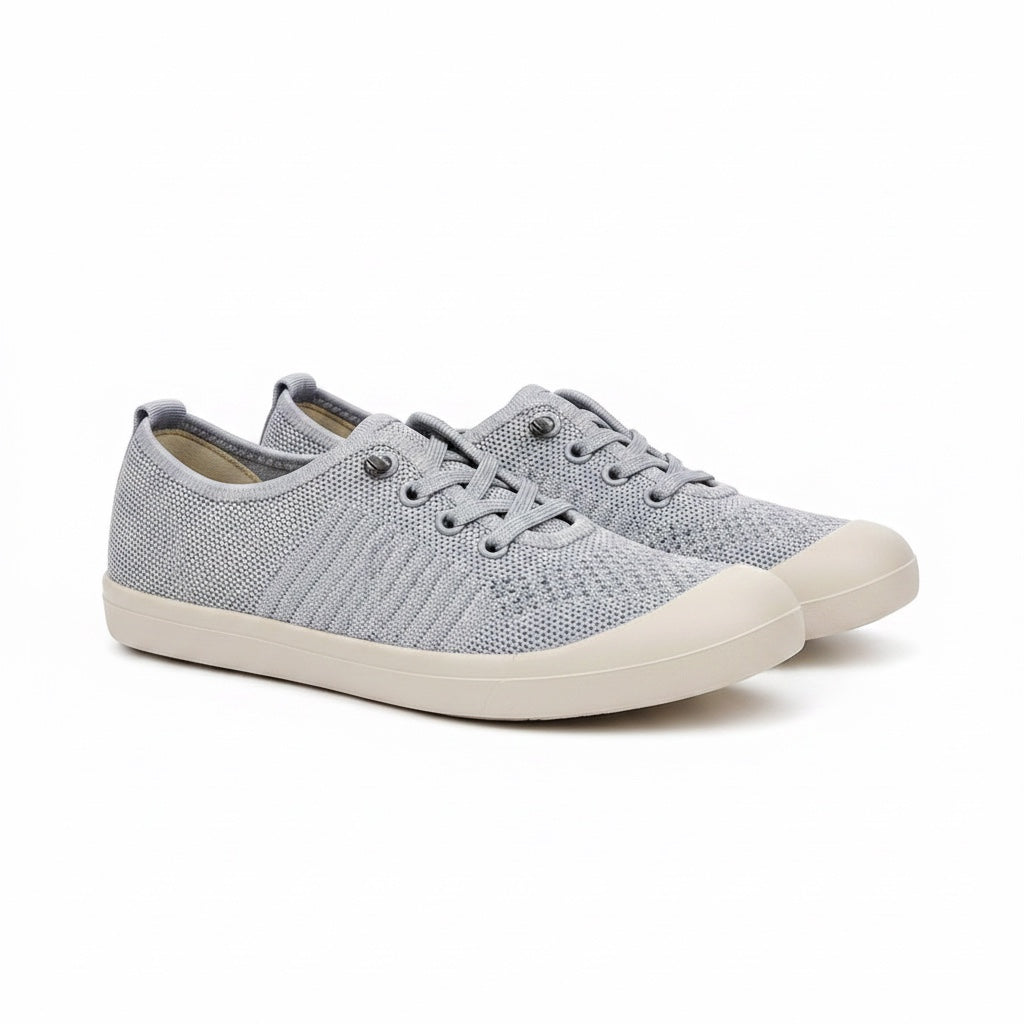 A pair of light grey knit slip on Loafers shoes with a white rubber sole.