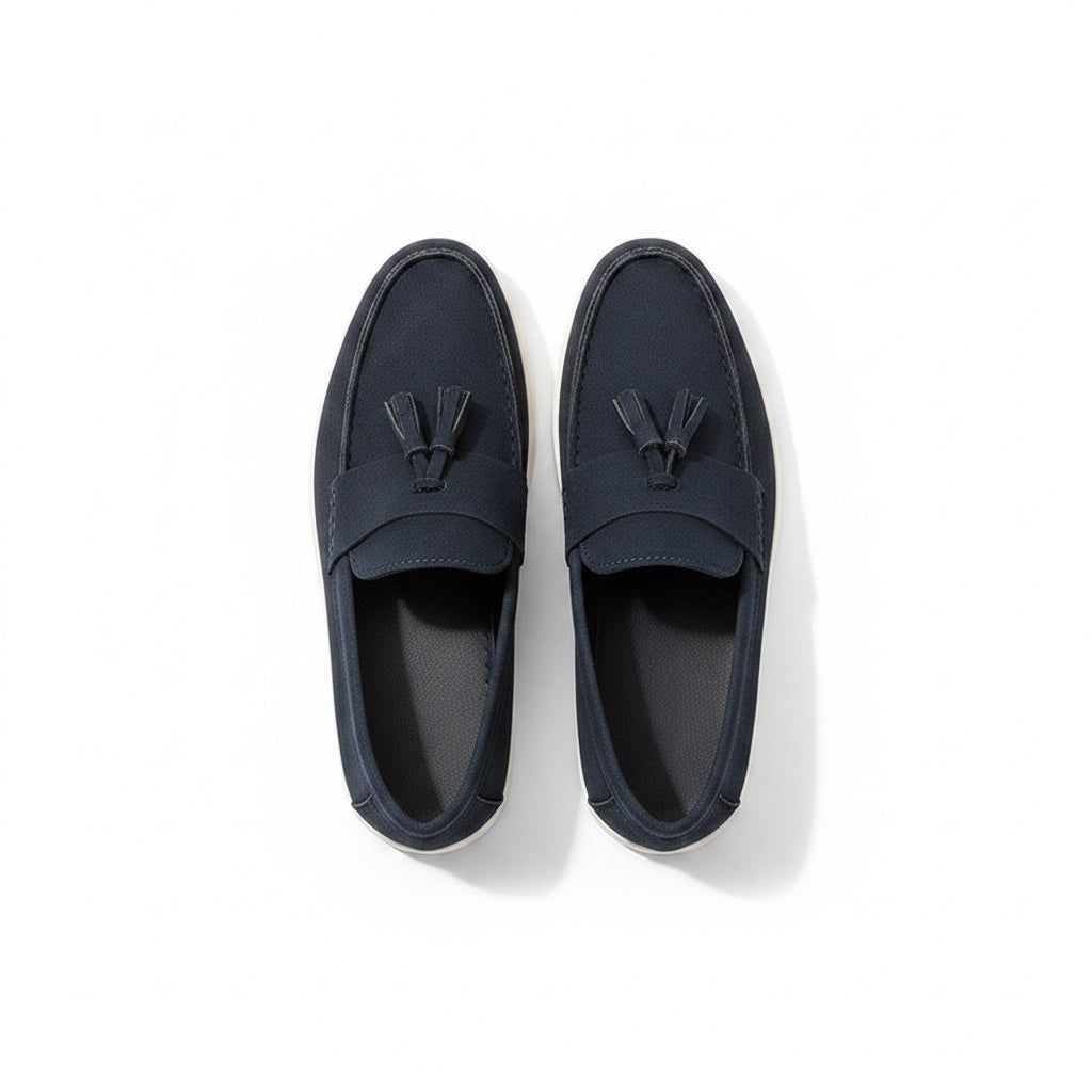 A pair of navy blue slip on loafers with tassel details.