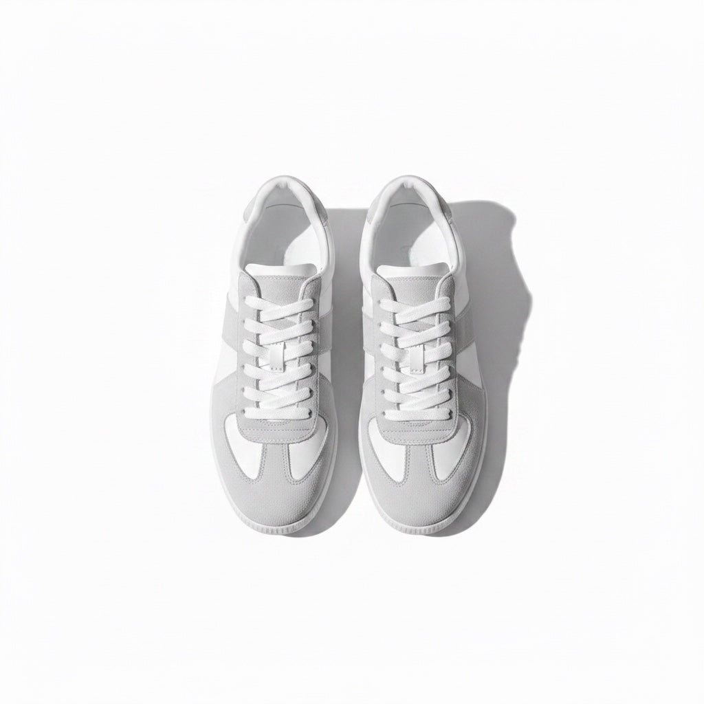 A pair of low top Loafers shoes in white and light grey, shown from a top down view. 
