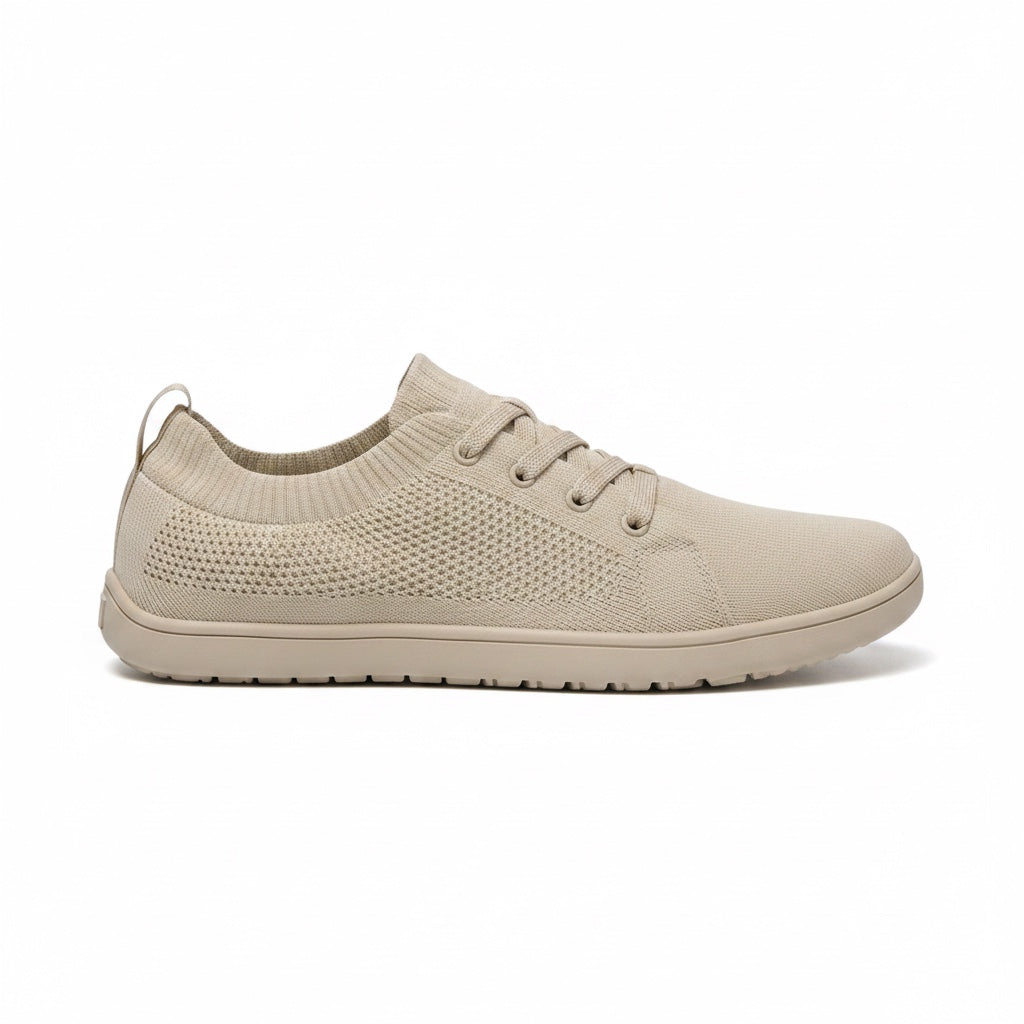 Beige men's knit barefoot shoe with lace up closure and textured rubber sole, shown from the side.