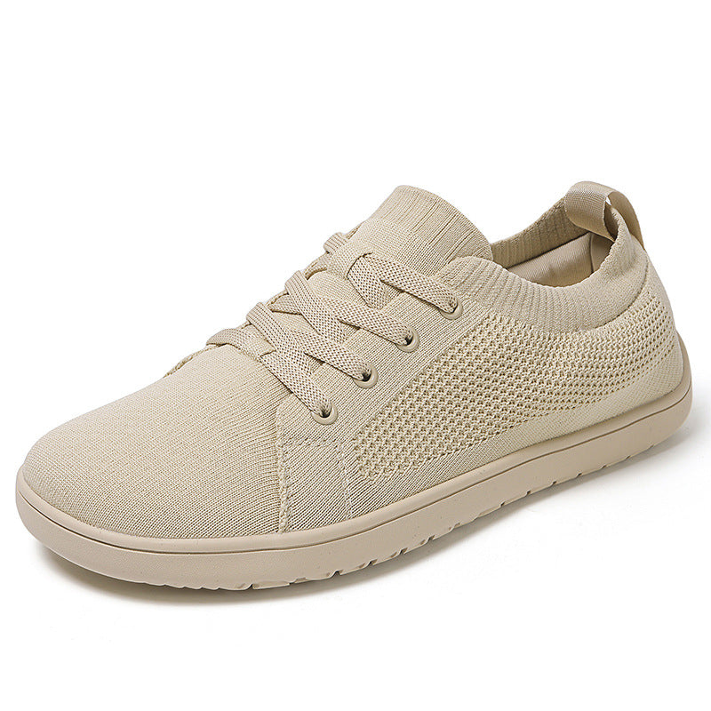Beige men's knit barefoot shoe displayed at an angled view, showing the laces, knit upper, and rubber sol