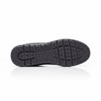 Bottom view of a black men's knit barefoot shoe showing the patterned traction outsole.