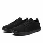 Pair of black men's knit barefoot shoes with lace-up fronts and lightweight rubber soles.