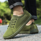 Person wearing olive green knit barefoot shoes, highlighting the casual everyday design.