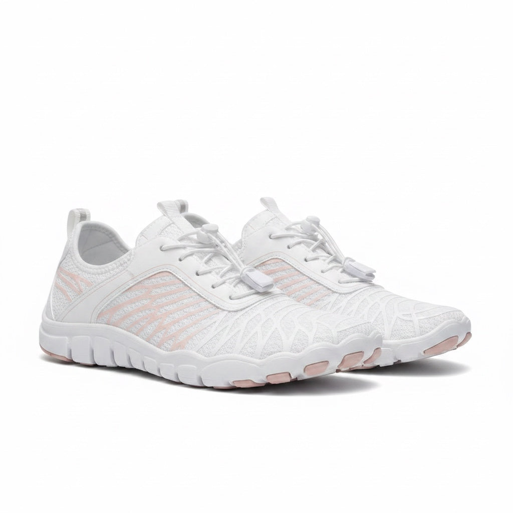 Angled pair of white Nomad barefoot shoes highlighting the lightweight upper and flexible sole.