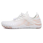 Pair of white Nomad barefoot shoes displaying their minimalist shape and flexible construction.