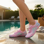 Pink barefoot shoes worn outdoors beside a pool, demonstrating their versatile everyday design.
