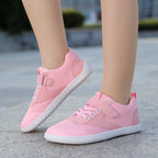 Pink children's  barefoot shoes with white soles.