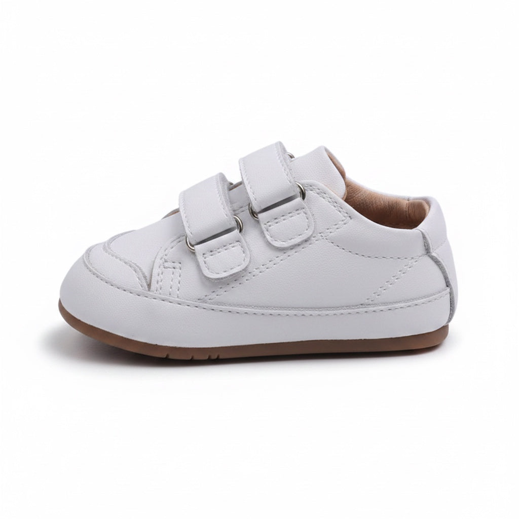Pair of white baby shoes with adjustable straps and lightweight flexible soles