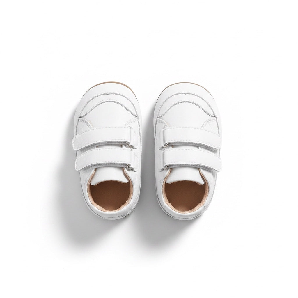 Top view of a pair of white baby shoes with adjustable double straps