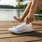 White barefoot shoes worn outdoors beside the water, demonstrating their versatile everyday design.