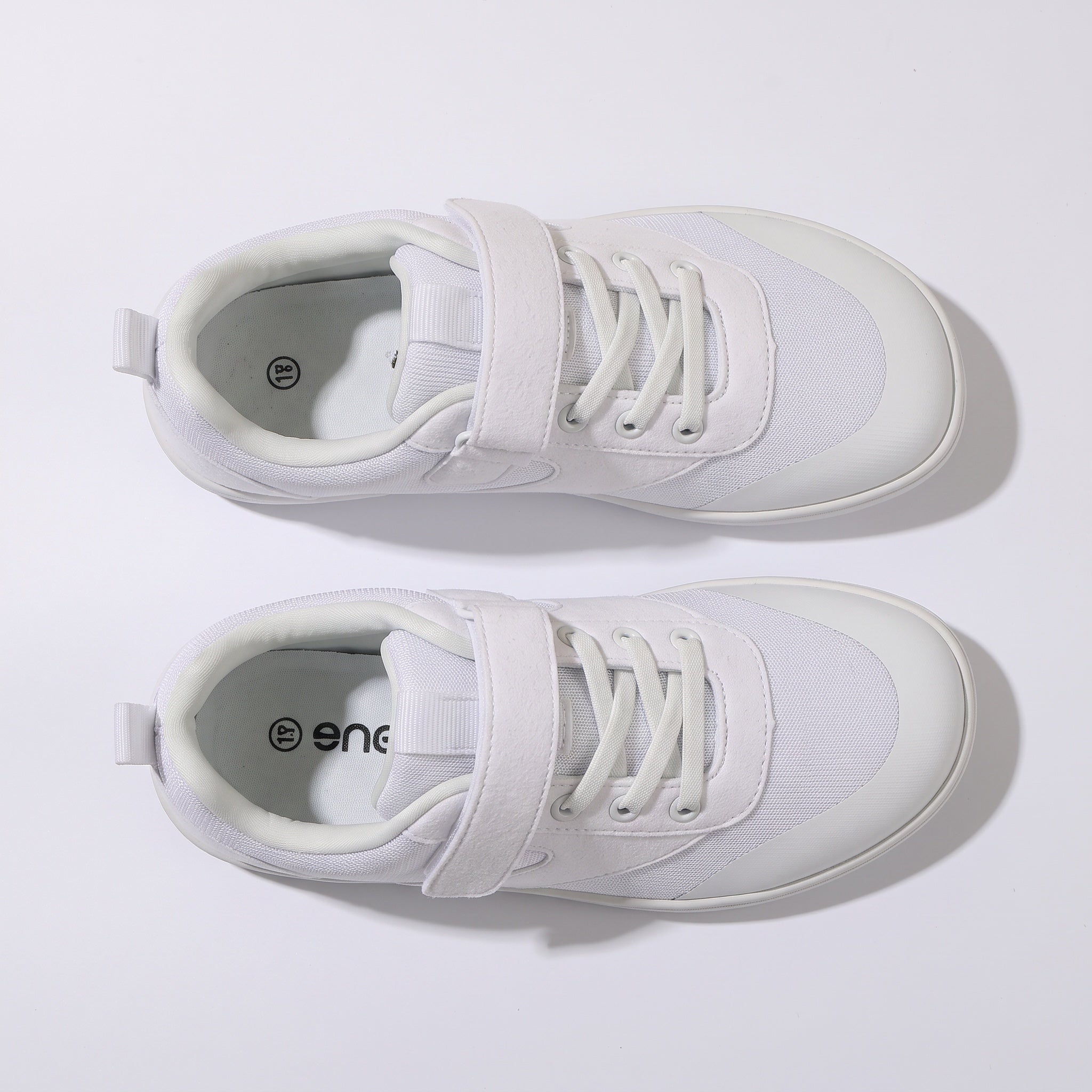 A pair of white barefoot children's shoes with white laces and rubber