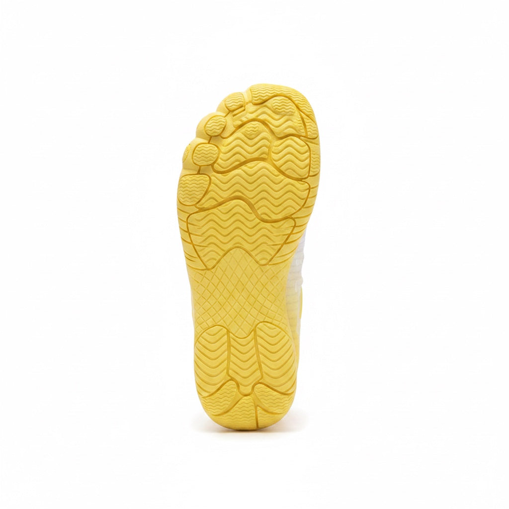 Bottom view of a yellow barefoot water shoe showing its textured flexible traction sole