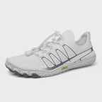 White barefoot shoes presented from an angled view, highlighting their lightweight design and flexible construction.